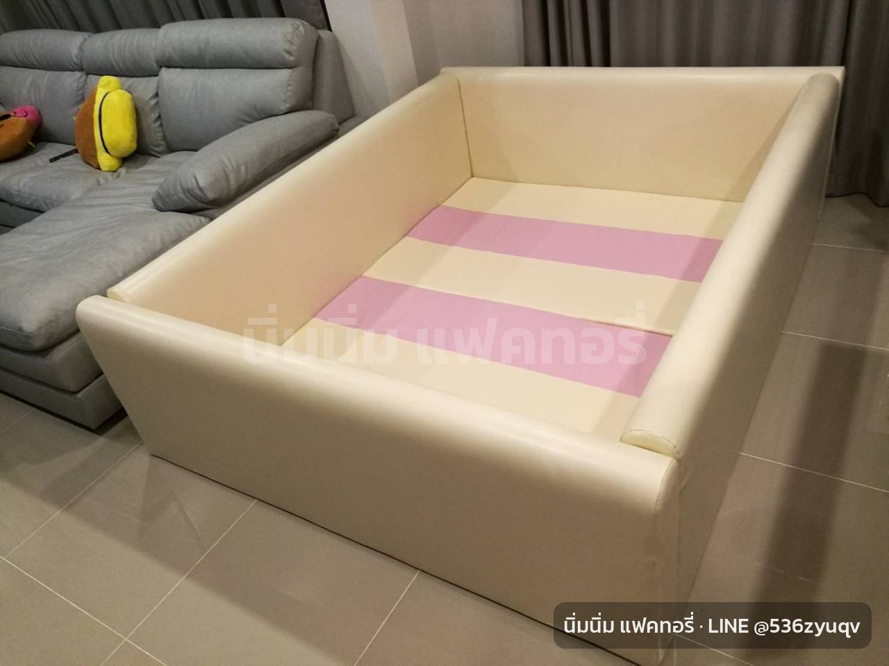 คอกกั้นเด็กนุ่มนิ่มสีครีมวางในบ้าน
